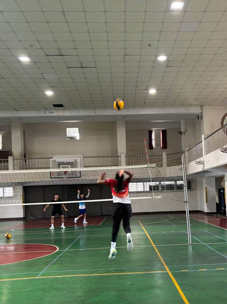 Teacher Z leaps to spike the ball over the net