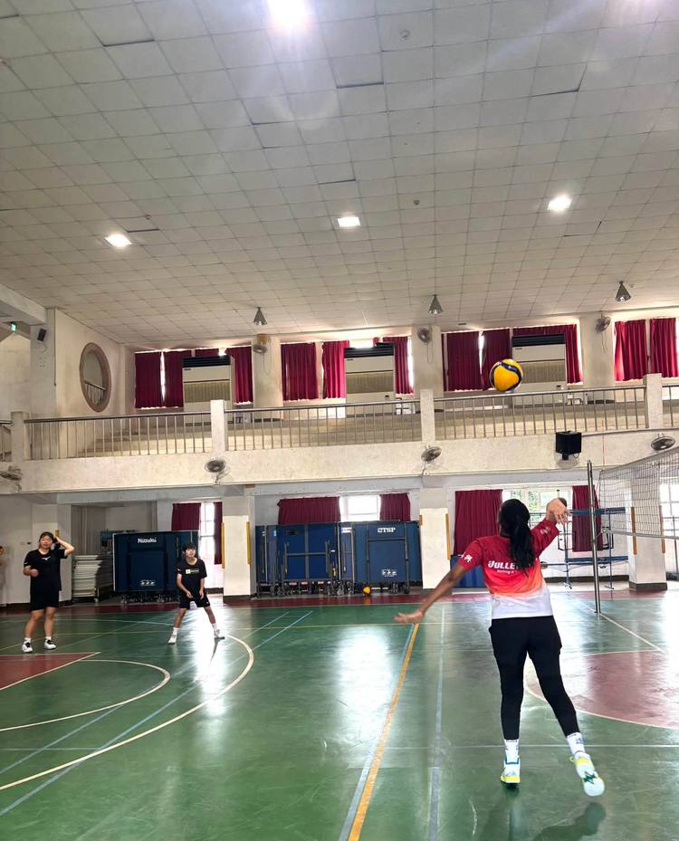 Teacher Z swings her arm to hit the ball during a drill