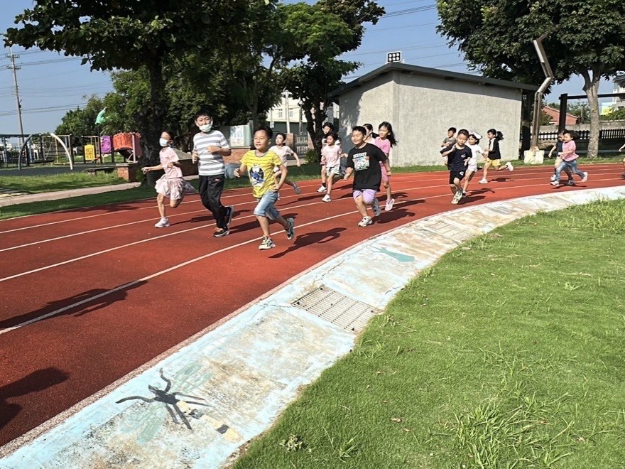 SH150 活動時間，學生在紅色跑道上晨跑，陽光灑在操場上