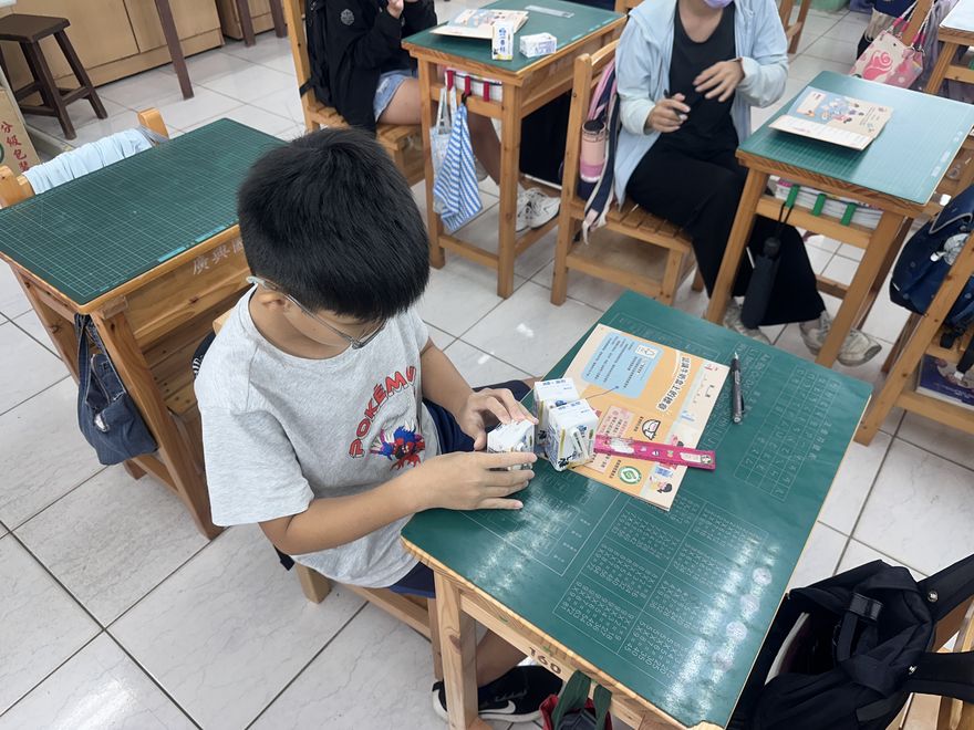學生動手操作補鈣大挑戰教材,手拿牛奶盒模型