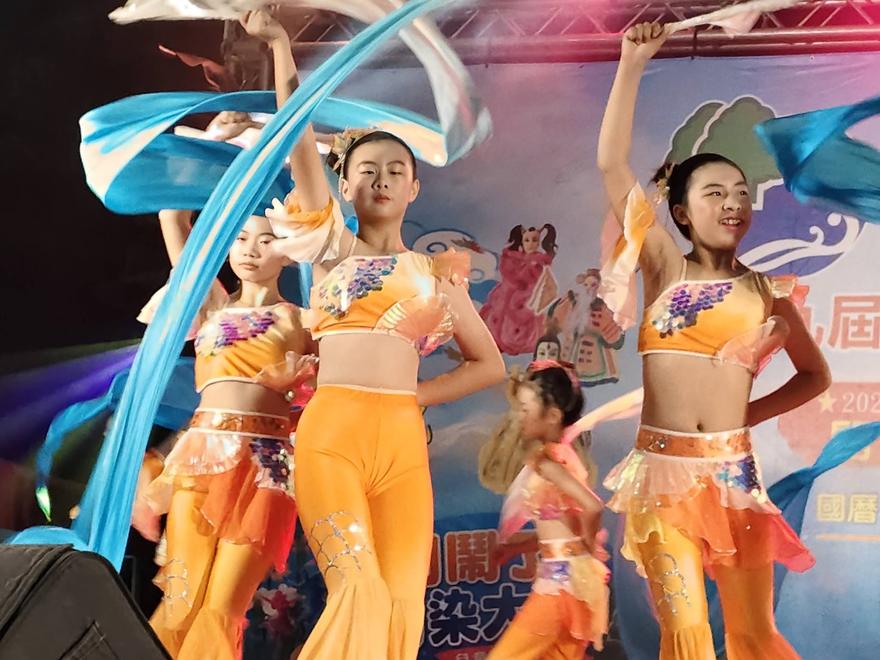 廣興舞蹈隊在舞台上揮舞藍色彩帶表演