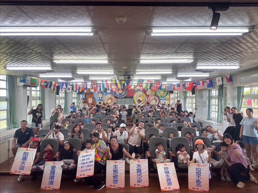 活動結束後的大合照，前排舉著阻塞水道、愛護環境、生態破壞、水質污染、珍惜水資源、垃圾不亂丟等標語牌