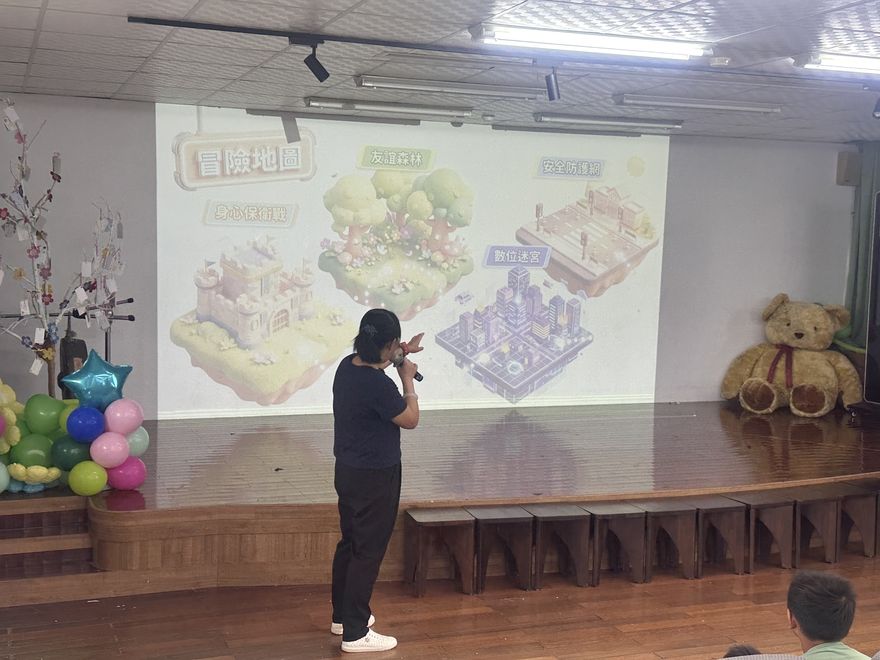 校長站在舞台前,用簡報帶學生進入情境題