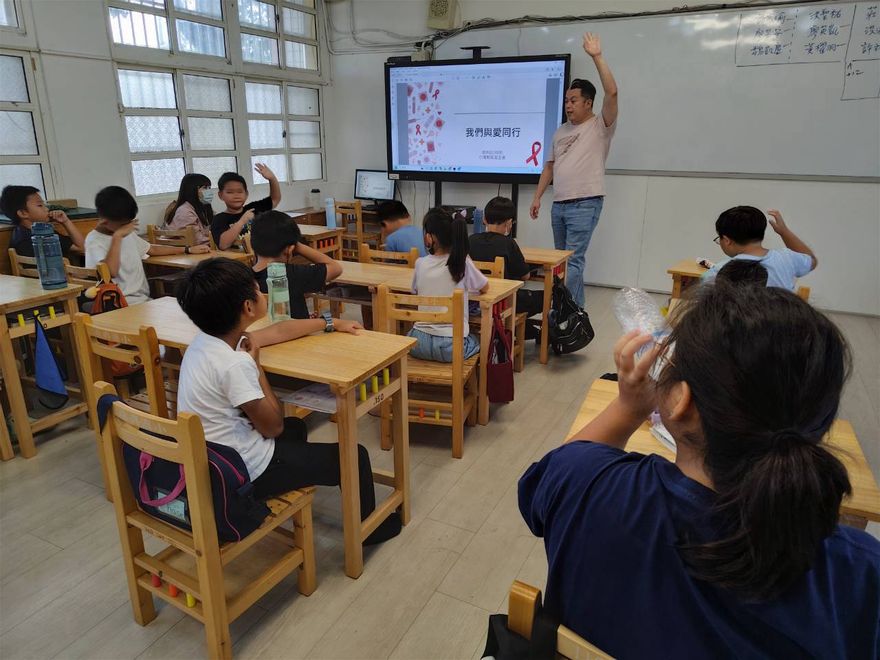 簡報上出現紅絲帶圖案，學生踴躍舉手回答問題