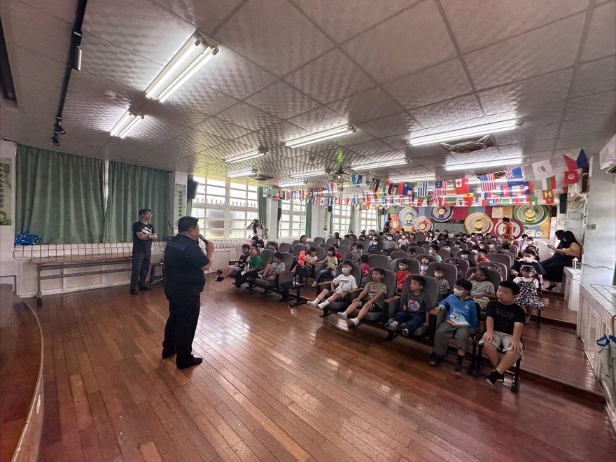 視聽教室全景，學校師長為金融素養宣導開場，全校學生就座聆聽