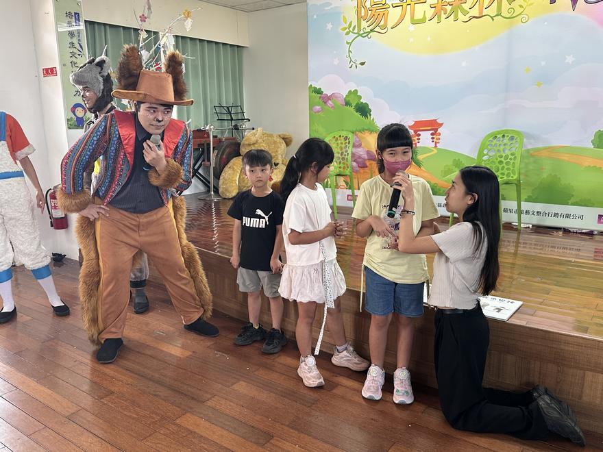 動物角色拿著麥克風，邀請學生上台回答問題