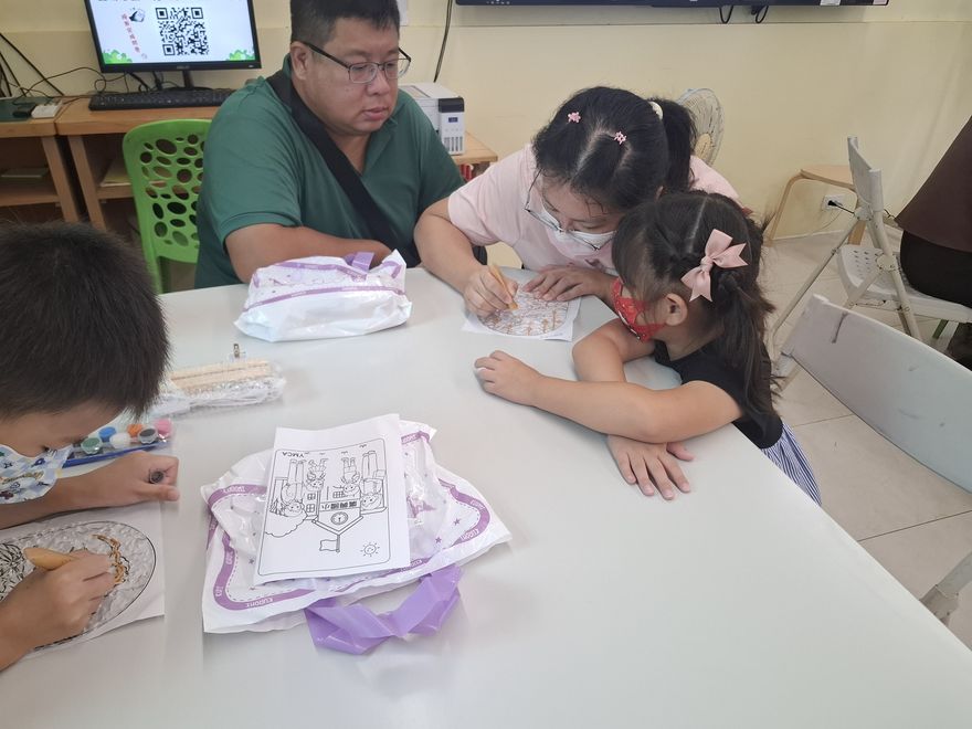 家長陪著兩個孩子一起完成手作提袋