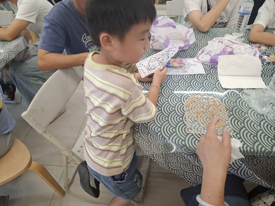 小男孩拿起自己的作品,開心地看著