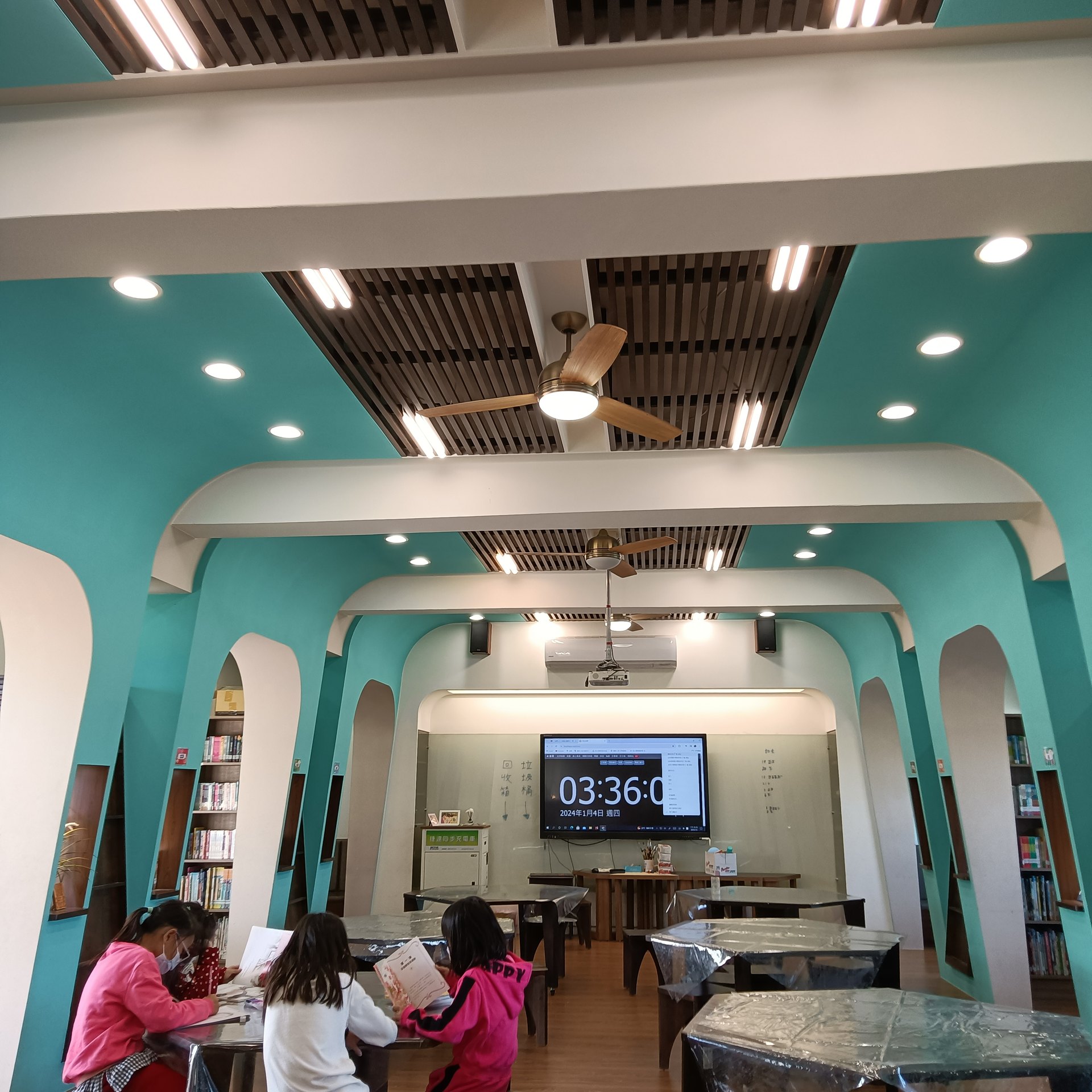 The teal-walled bilingual reading station inside Guangxing campus 廣興校園裡的雙語共讀站