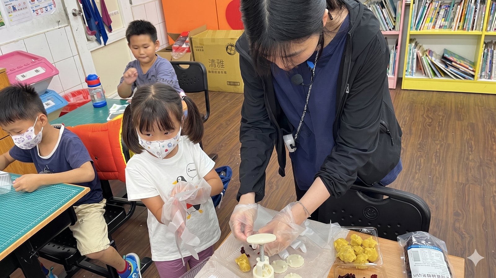 Teacher showing first graders how to make moon-cakes 老師示範月餅製作