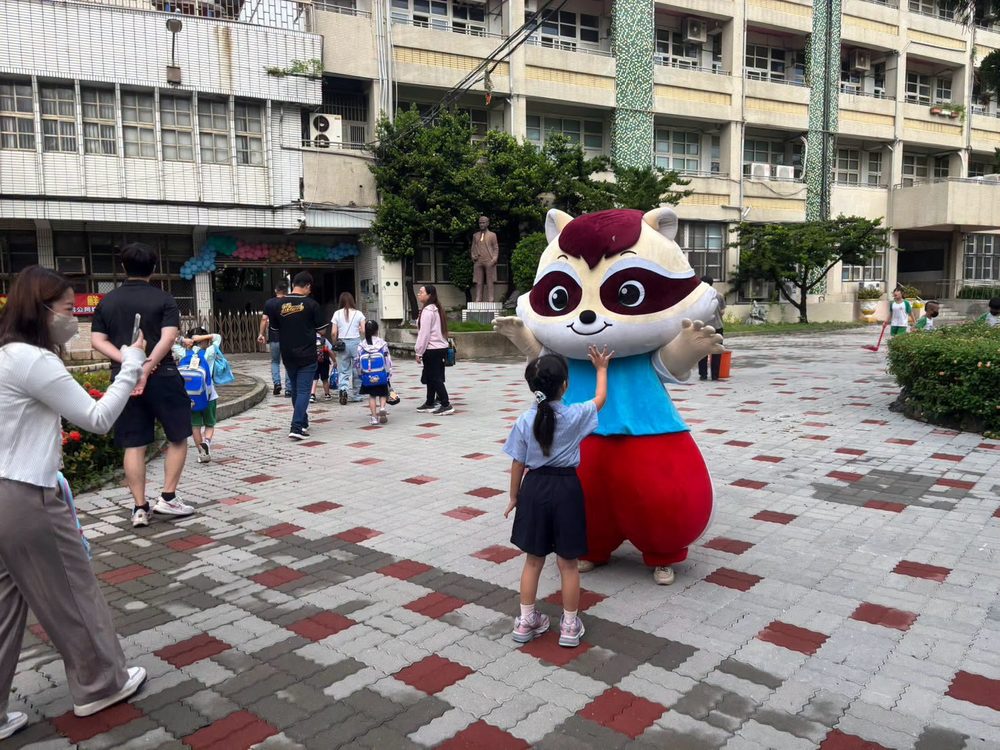 A mascot greets a child