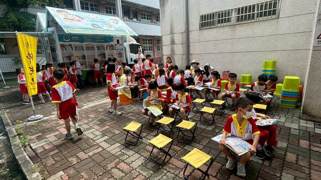 和仁國小學生坐在戶外小椅子上專心閱讀