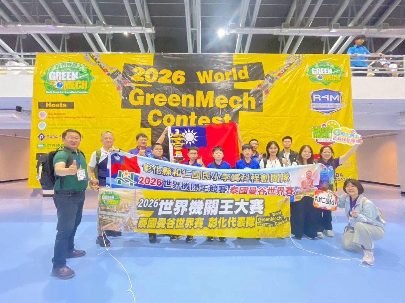 和仁國小資科程創團隊在世界機關王競賽會場與國旗合影
