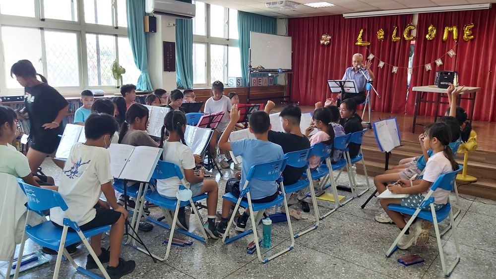 Students practising harmonica in the school hall