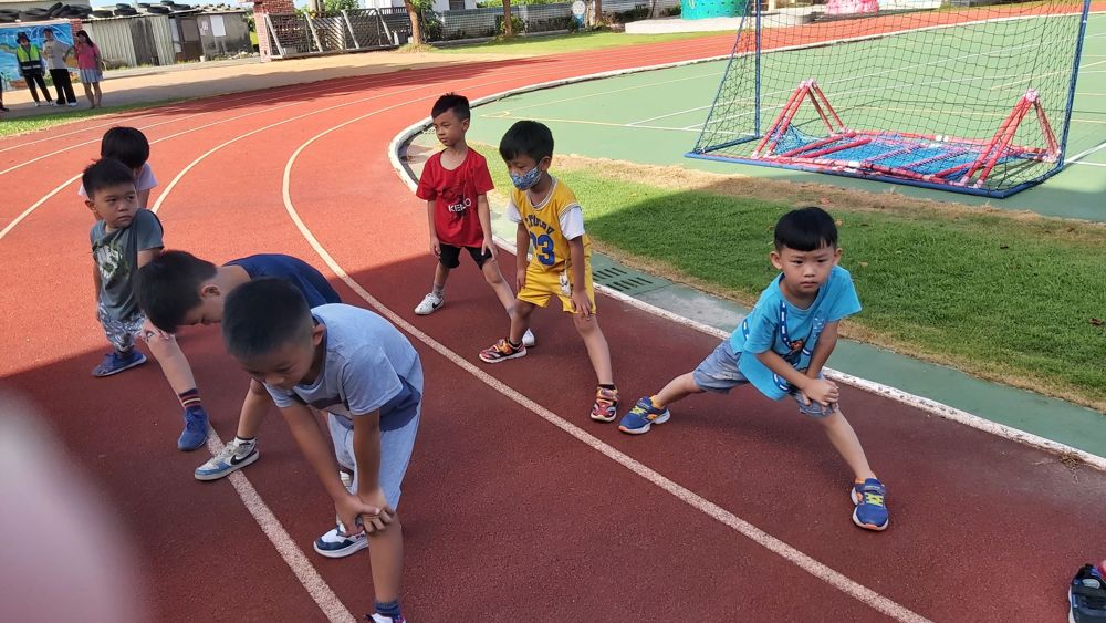 Students running together on the red track