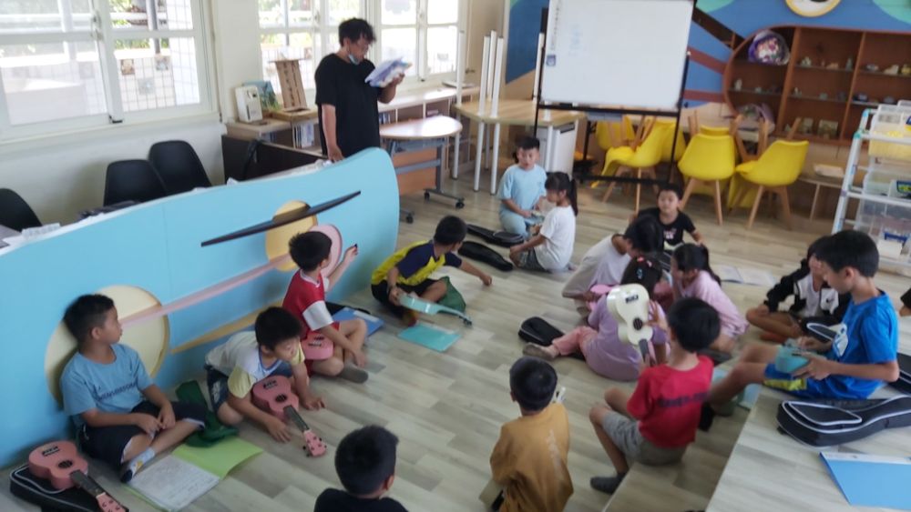 Young students holding ukuleles in class