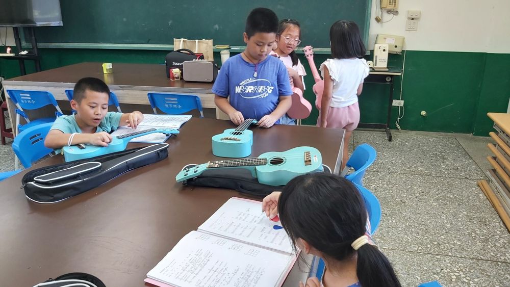 Children practising the ukulele together