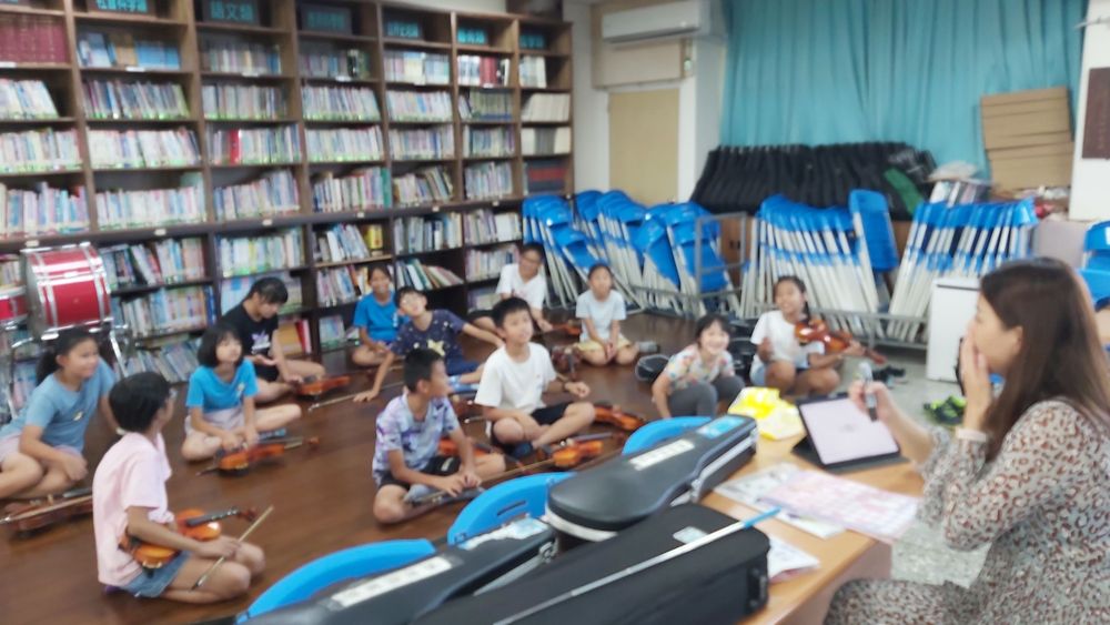 Students playing violin together in the library