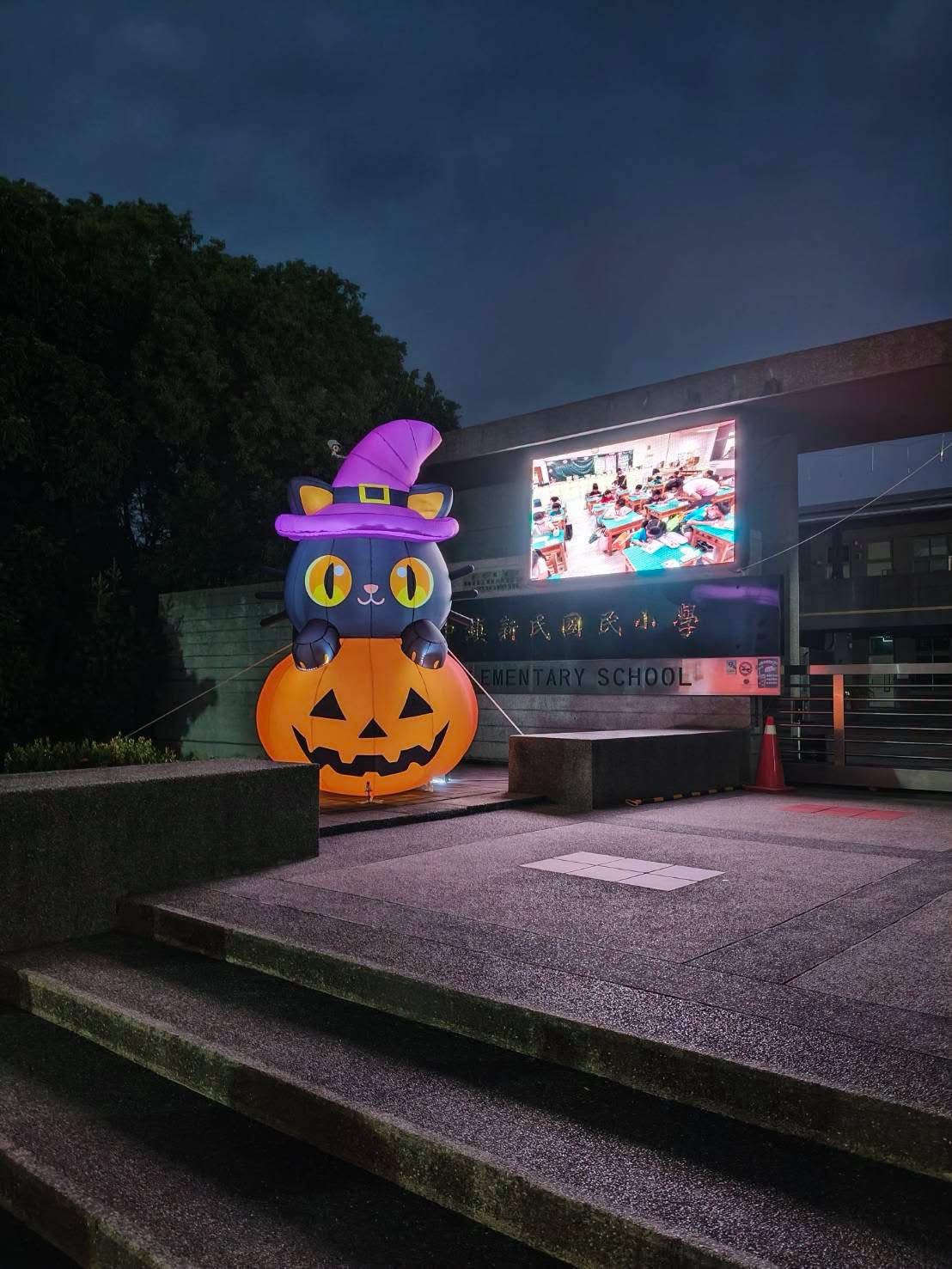 夜晚的黑貓南瓜造型氣球在校門口發光