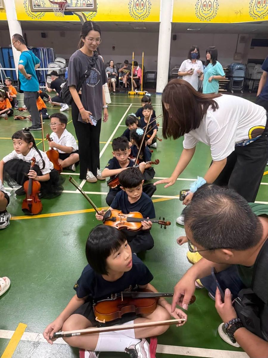 比賽前老師指導孩子拉琴姿勢