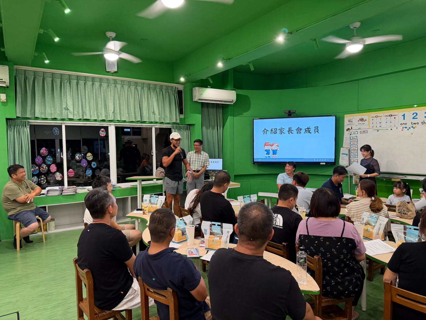 家長委員們在藝語樂齡教室參與會議，螢幕顯示介紹家長會成員