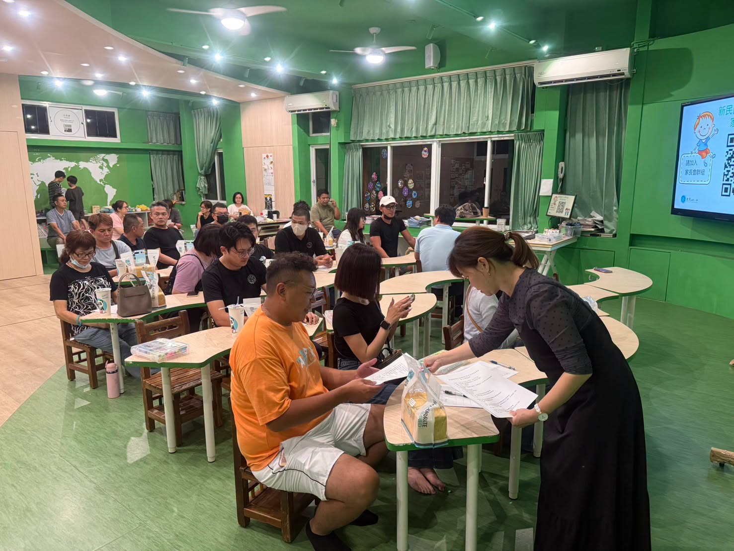 新民國小家長委員會議現場，委員們在藝語樂齡教室翻閱資料