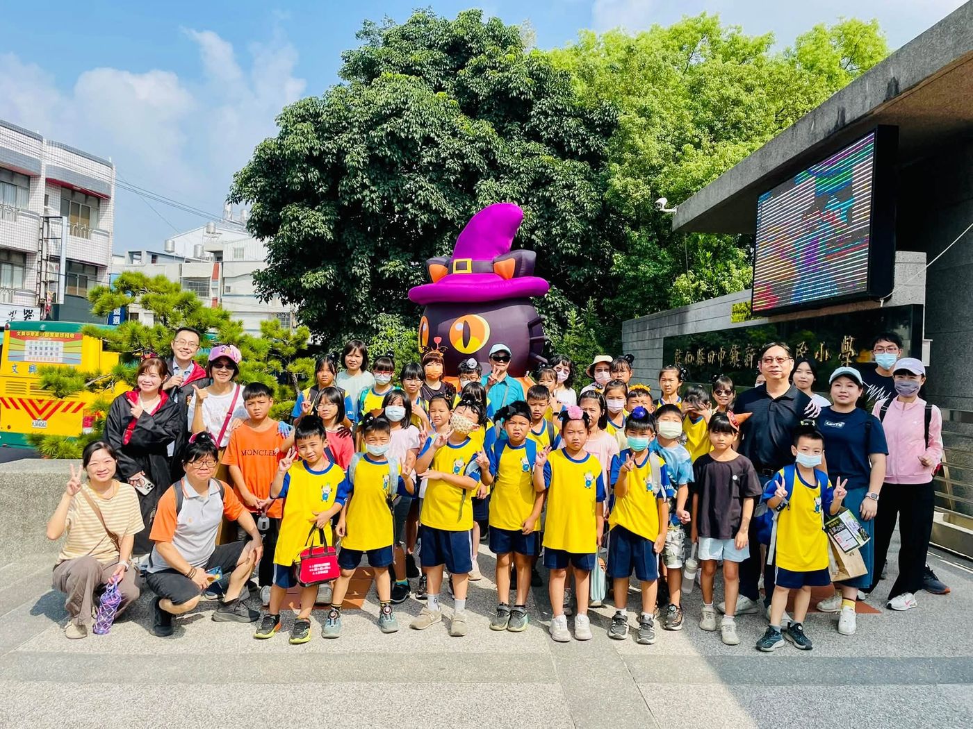 水尾國小師生在新民國小校門口黑貓南瓜前合影