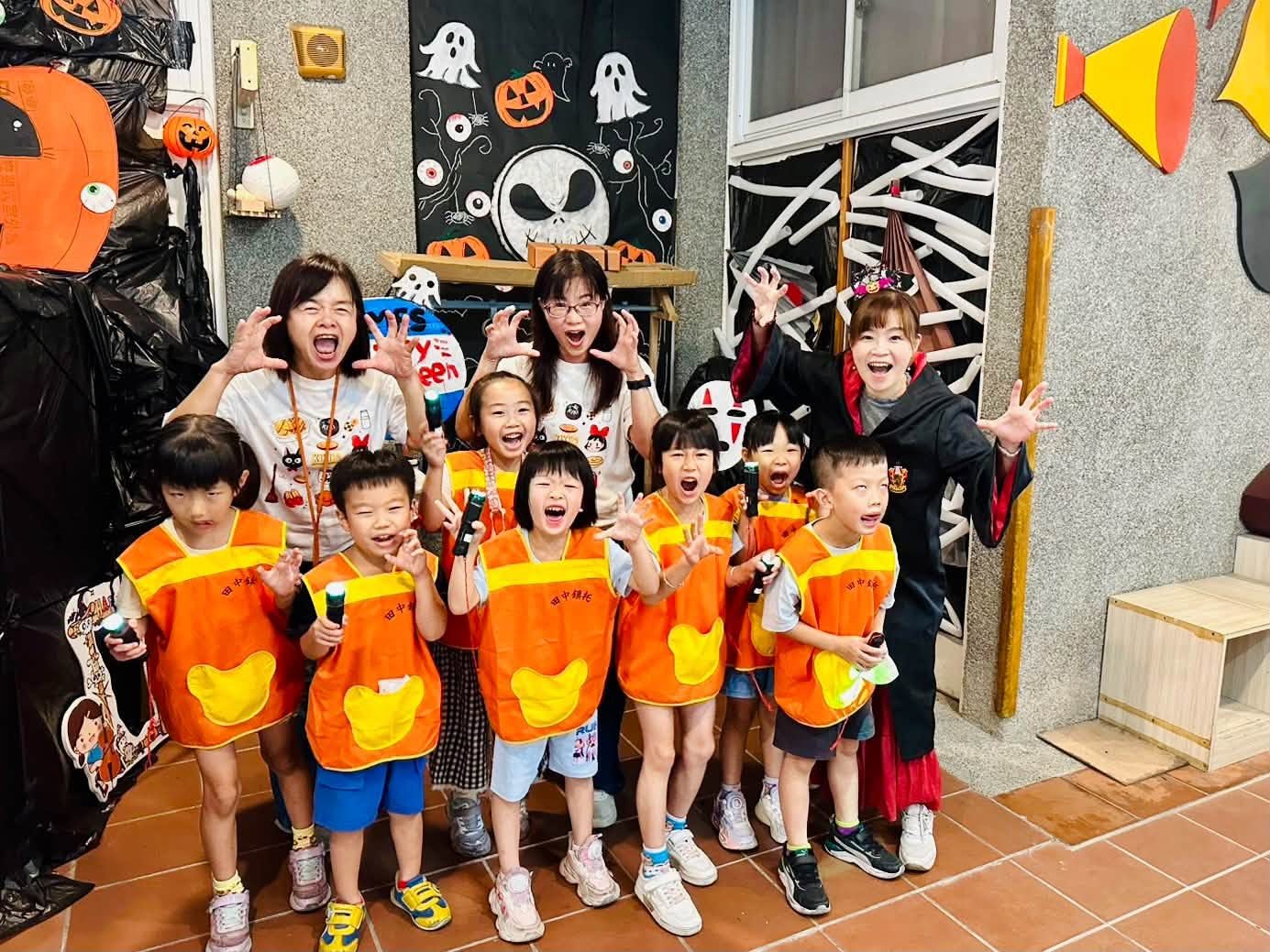 幼兒園小朋友穿著南瓜圍兜在怪怪屋裡開心合影