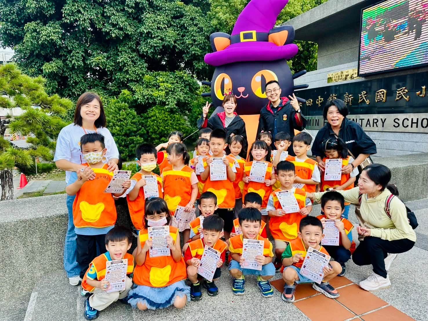 幼兒園小朋友在新民校門口黑貓南瓜前合影