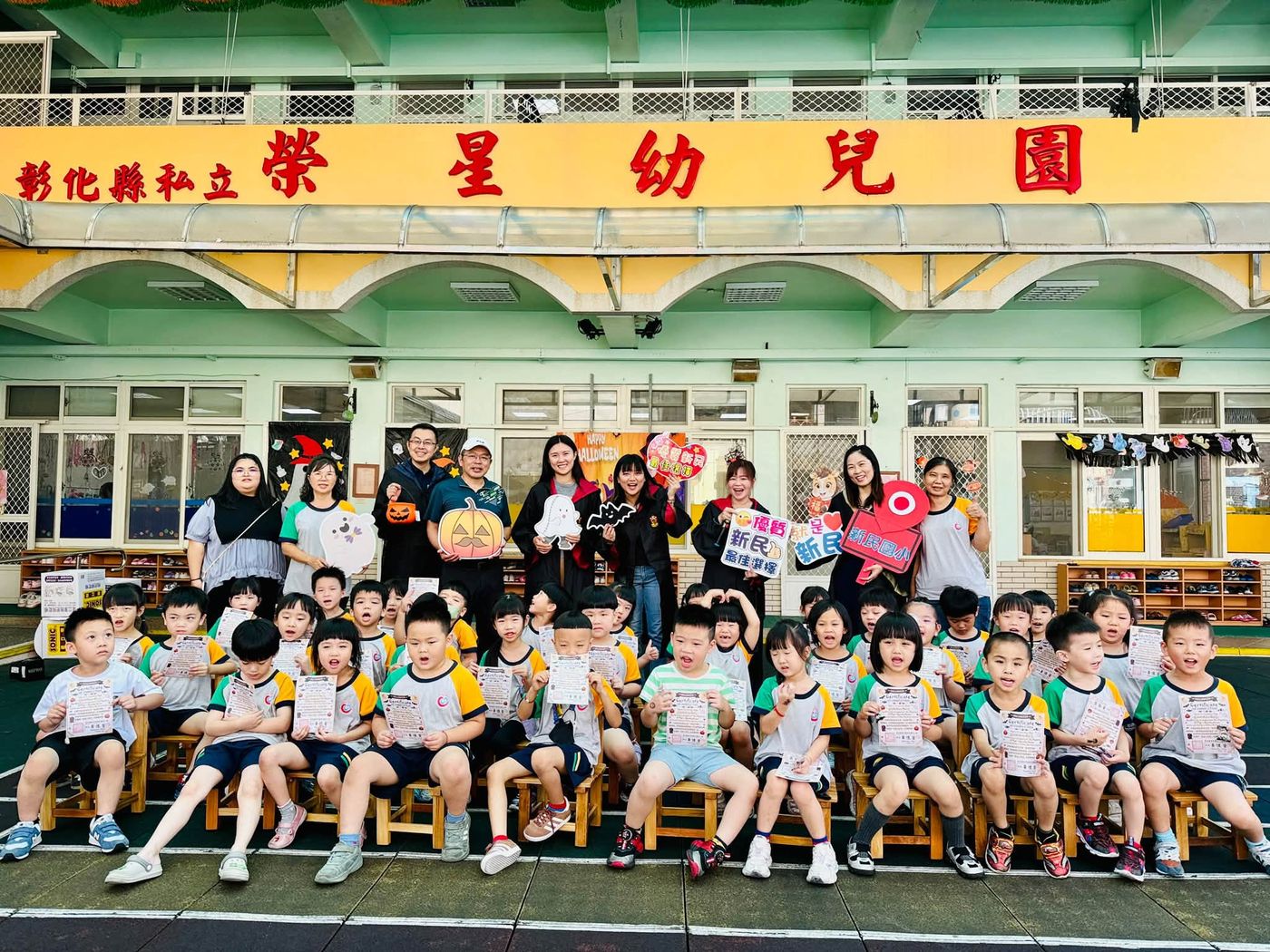 新民國小團隊與榮星幼兒園小朋友在幼兒園前拿著勇氣證書大合照