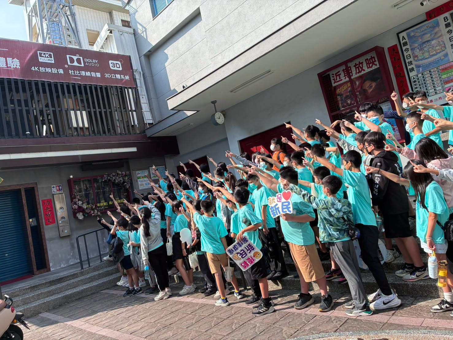 新民國小學生在電影院門口歡呼合影