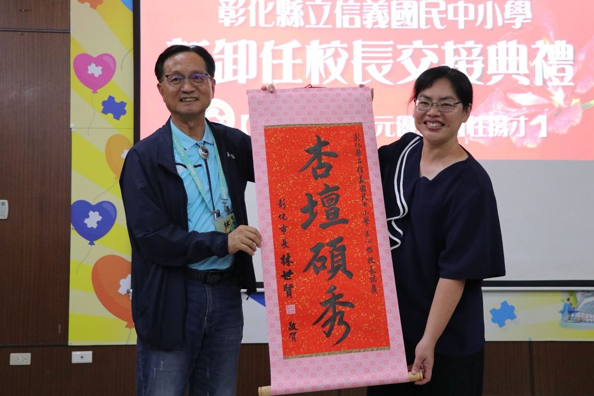 Principal Wang receiving a commemorative scroll at the inaugural ceremony 王心怡校長於交接典禮受贈賀軸