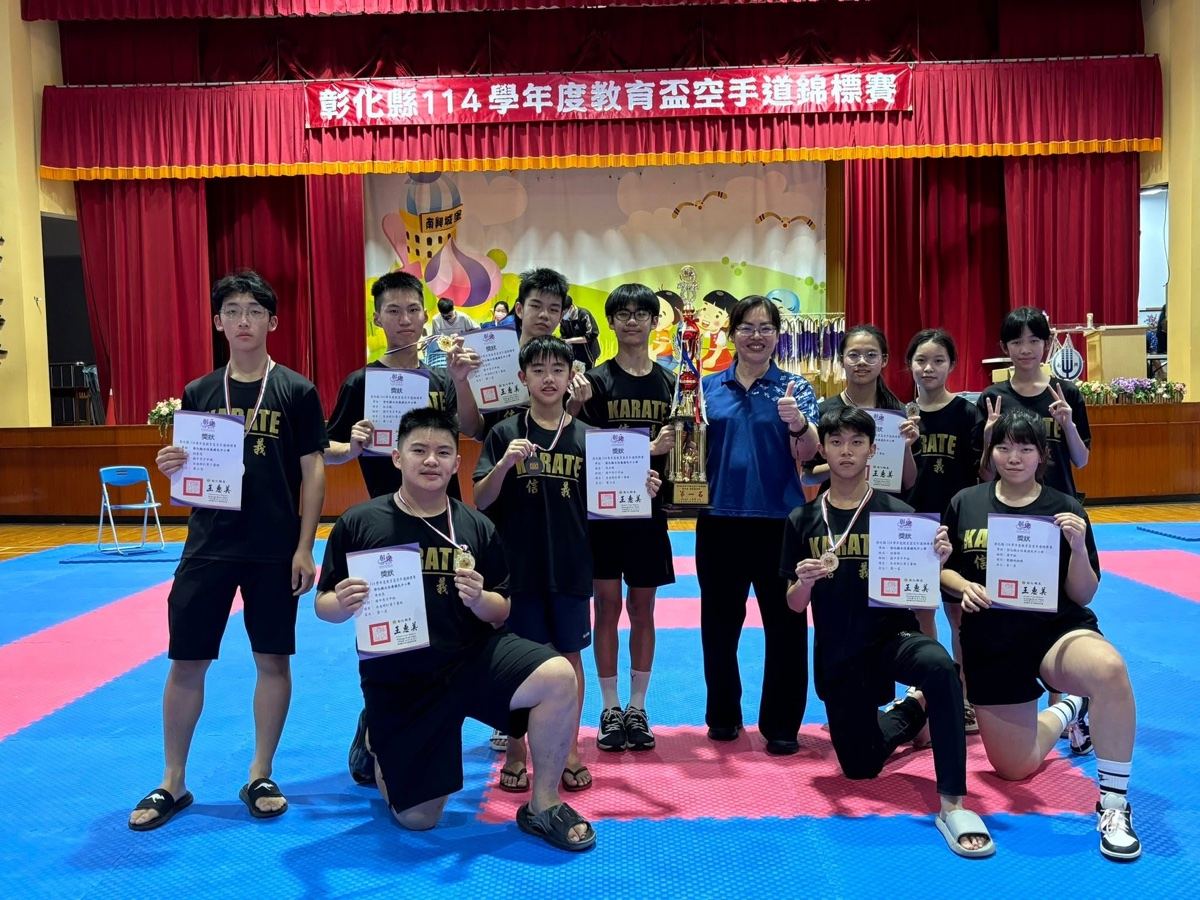 Principal Wang celebrating with the karate team and their trophy 王心怡校長與空手道隊及獎盃合影