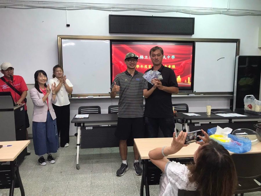 家長會議上，家長會長挹注籃球隊發展基金 At a parents' association meeting, a donation is made to the basketball team's development fund
