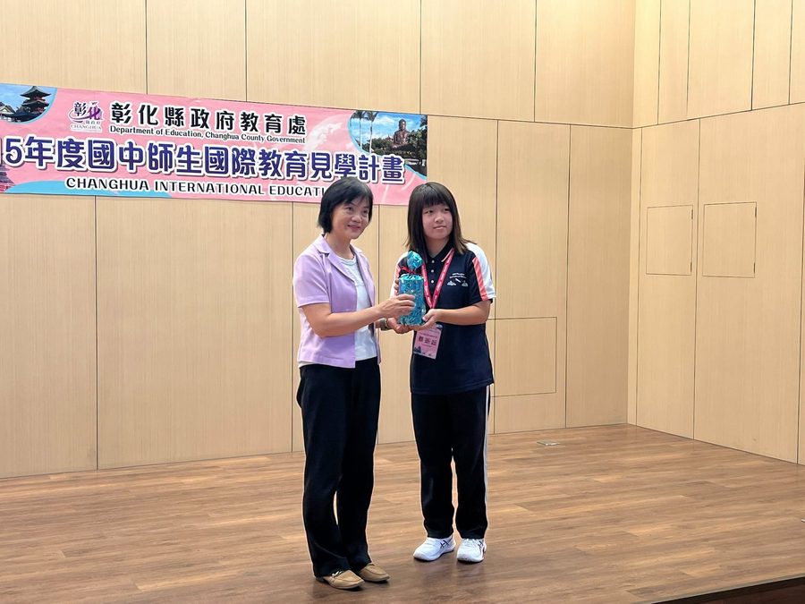 秀水國中九年級同學在成果發表會上台領取名片設計優良獎 A Hsiushui ninth-grader receiving the business-card design Excellence Award on stage