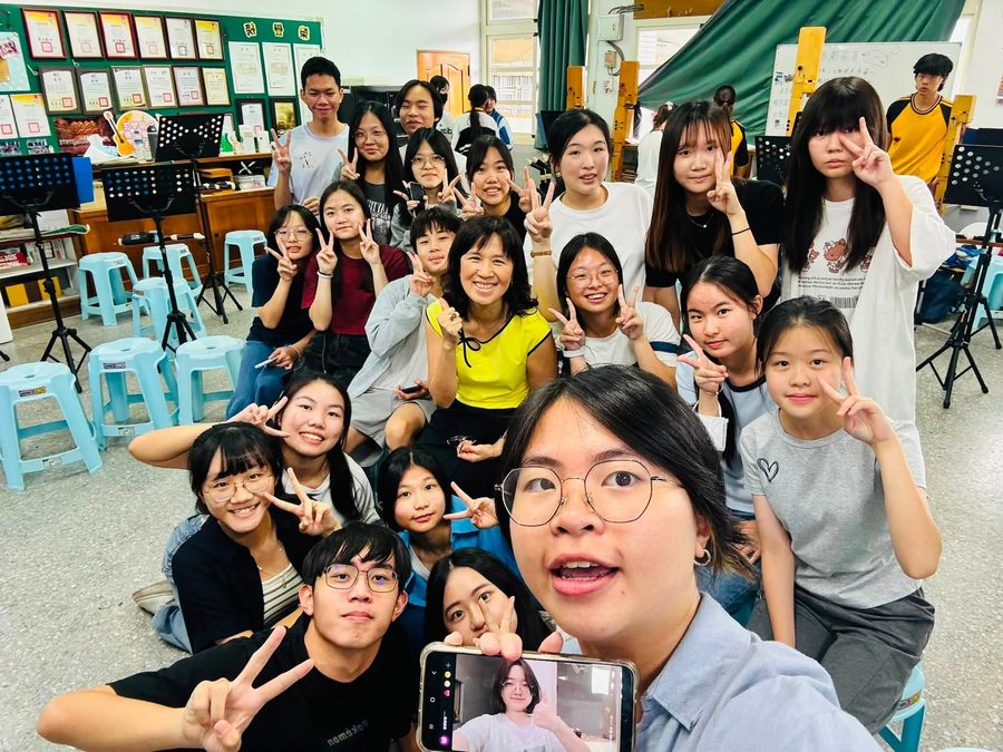直笛隊學長姐與團員圍著老師自拍合照 Recorder ensemble graduates and members crowding around their teacher for a selfie