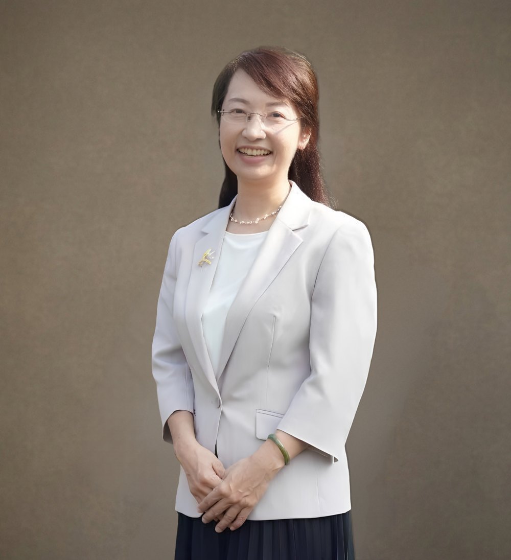 賴姵伶校長身穿淺灰色西裝外套，面帶微笑 · Principal Lai Pei-ling of Hsiushui Junior High School, smiling, in a light gray blazer
