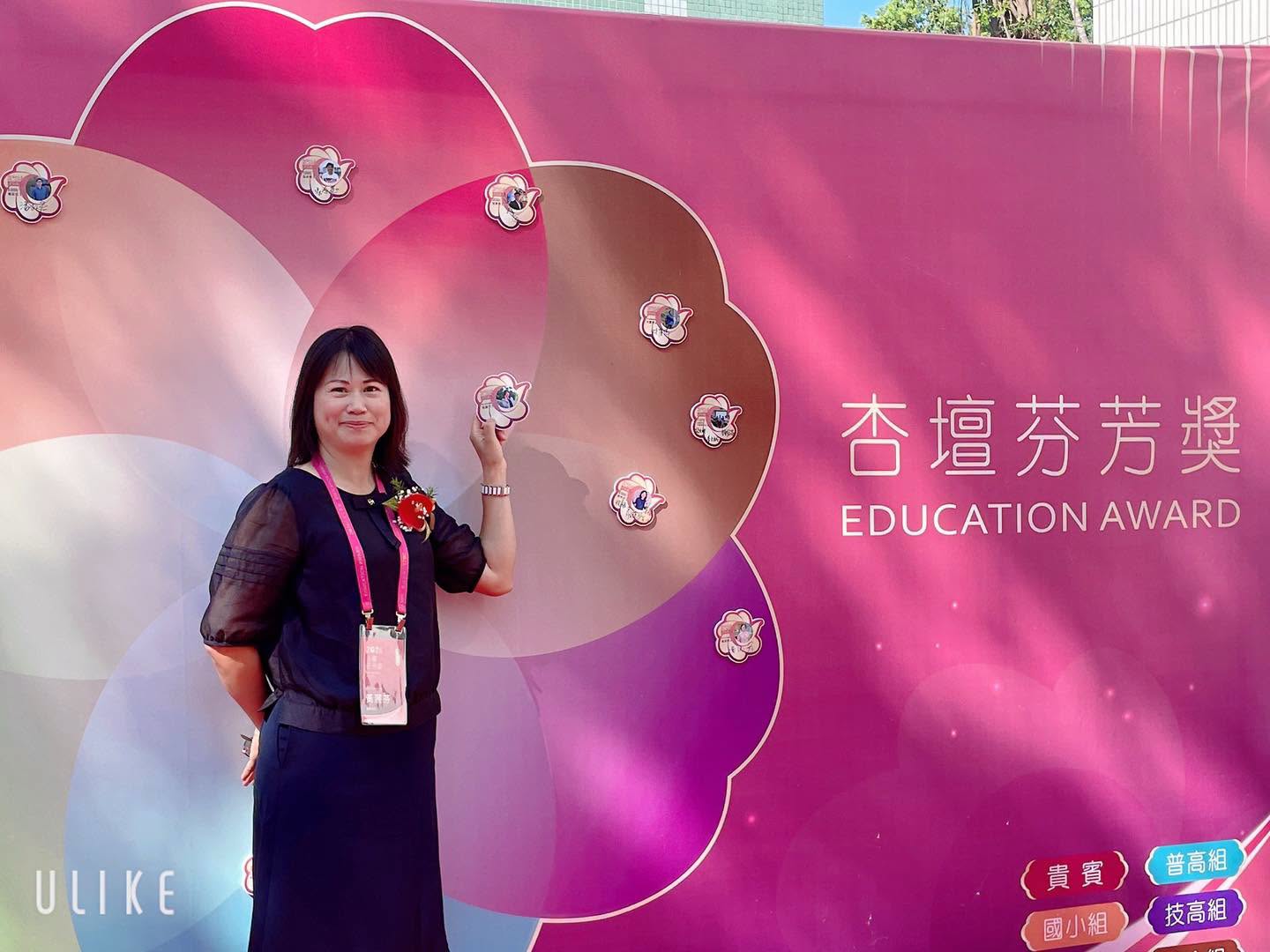 Huang Li-fen in front of the 2026 Education Award backdrop at the ceremony venue 黃麗芬主任於2026杏壇芬芳獎會場主視覺背板前留影