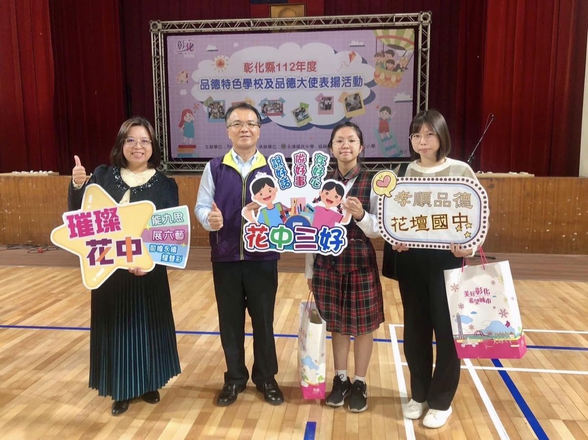 Huatan staff holding signs reading 璀璨花中 and 花中三好 at a county character education event 花壇國中教職員手持璀璨花中與花中三好標語牌