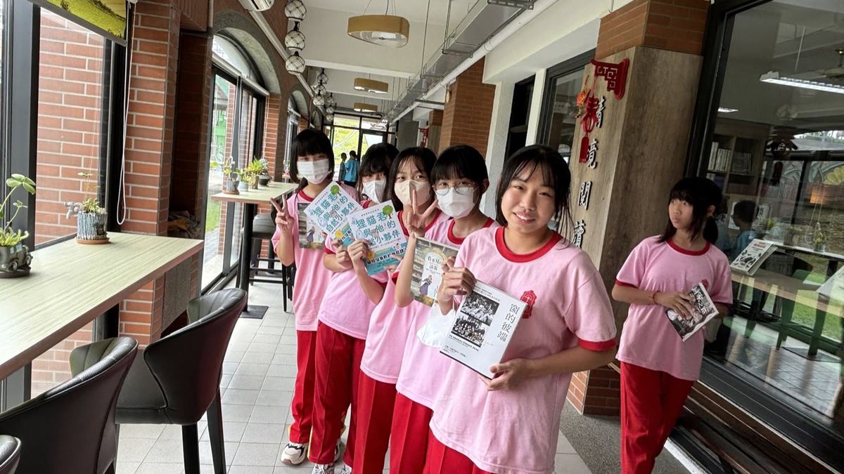 Huatan students holding their own hand-made books at the school's reading corner 花壇國中學生於共讀站展示自製小書