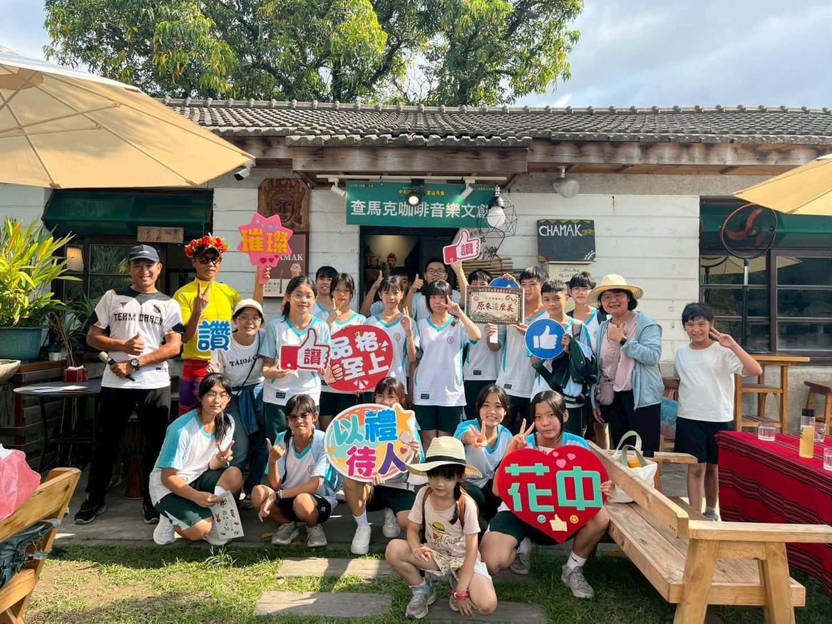 Huatan students and teachers posing with signs outside Camak Music & Creative Space 花壇國中師生於查馬克音樂文創空間前合影