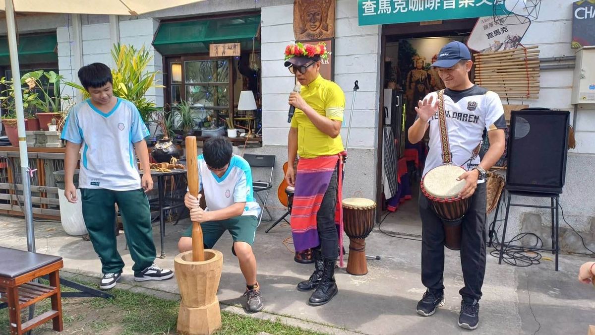 A Huatan student pounding millet in a wooden mortar 花壇國中學生手持木杵搗製小米