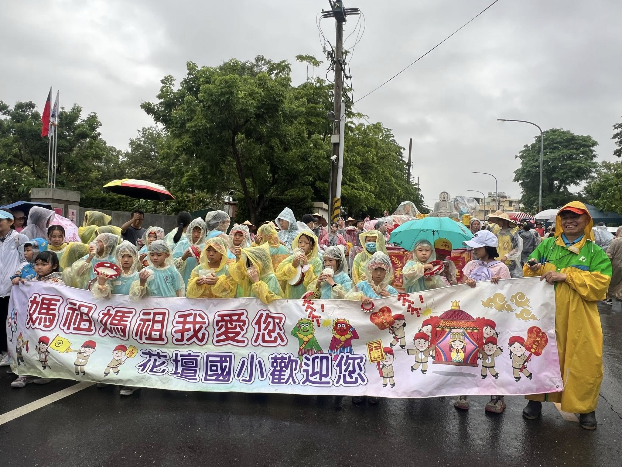 Students welcoming Mazu pilgrimage in the rain
