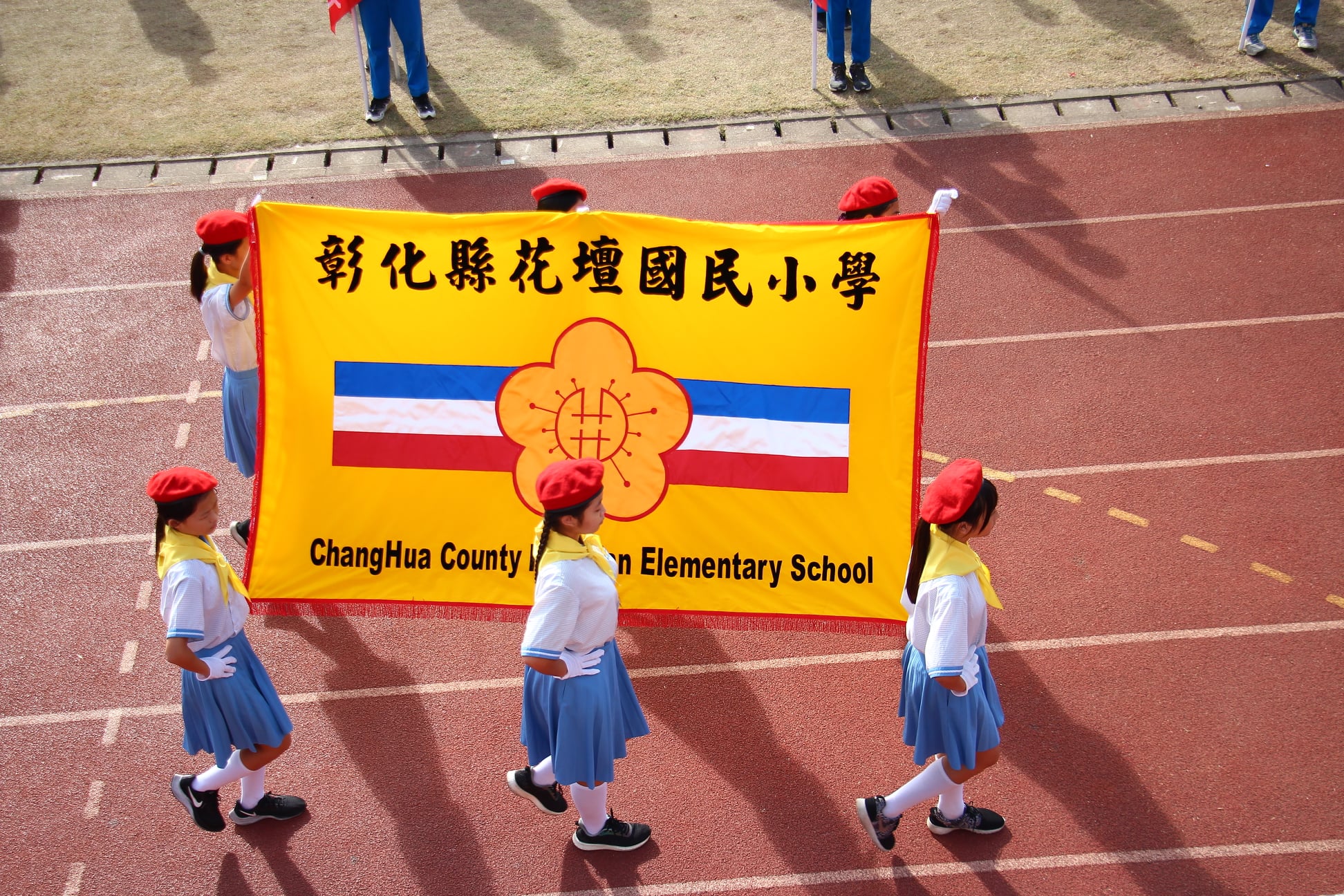 Huatan students carrying school banner