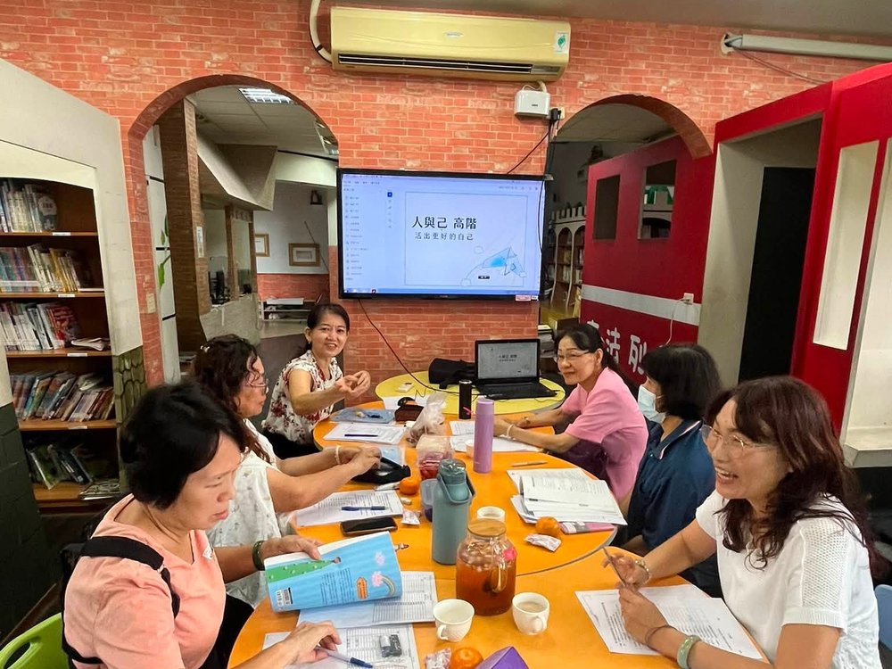 志工團隊圓桌討論，螢幕上是「人與己」的課程主題