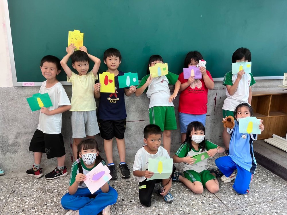 孩子們在教室裡手持自己的紙拼貼作品