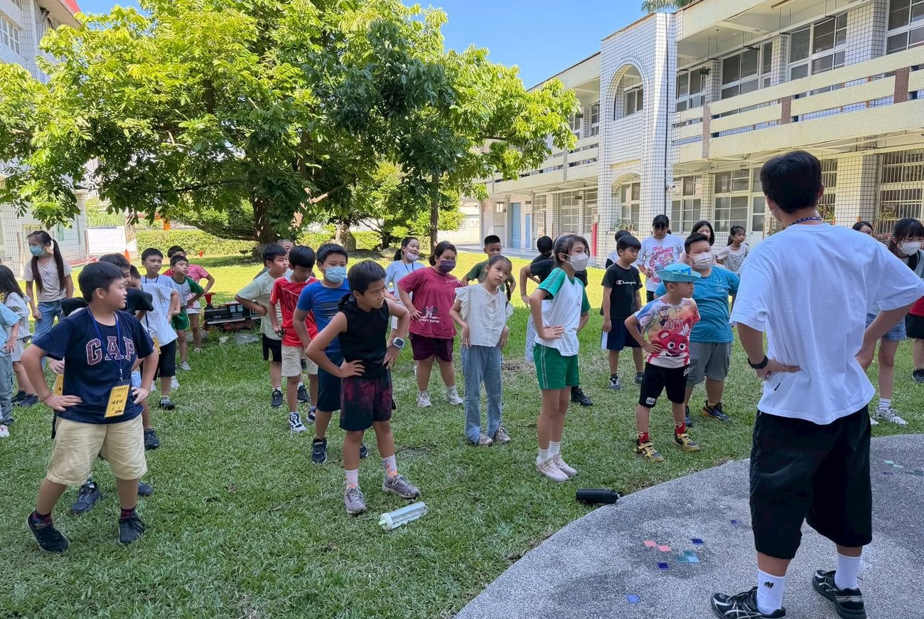 大專營隊帶領孩子們在校園草地上進行晨間活動