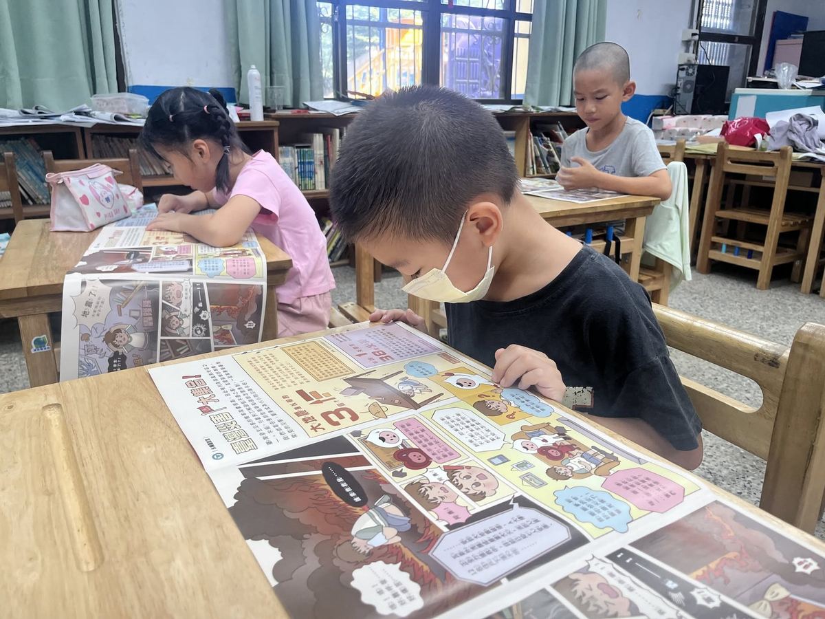 快官國小老師協助學生閱讀晨讀報紙
