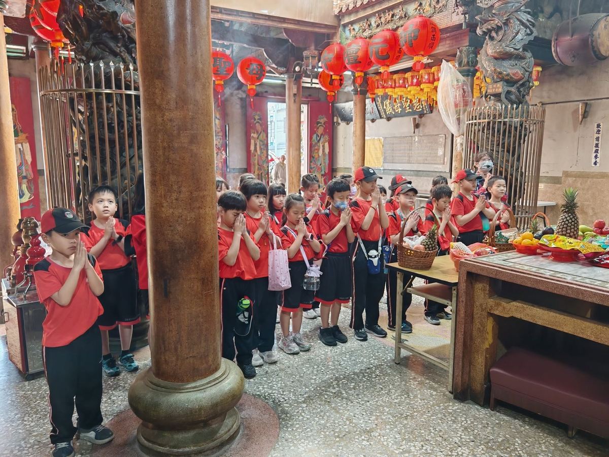 學生在廟裡雙手合十參拜
