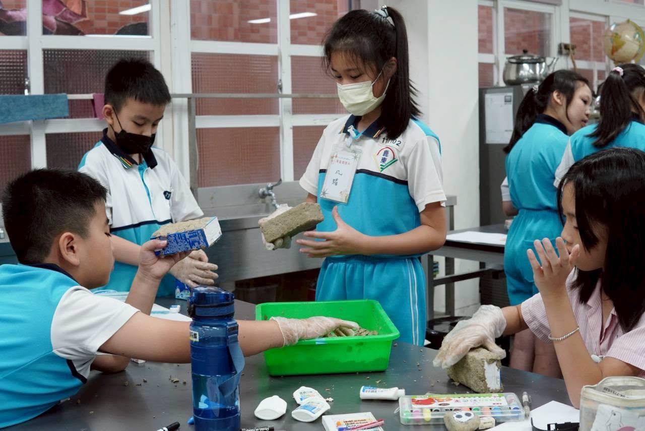 Students shaping recycled paper pulp into stone-shaped crafts